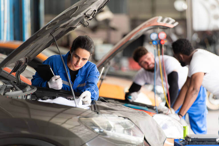 Car Mechanic Working In An Auto Repair Shop, Inspecting The Oper