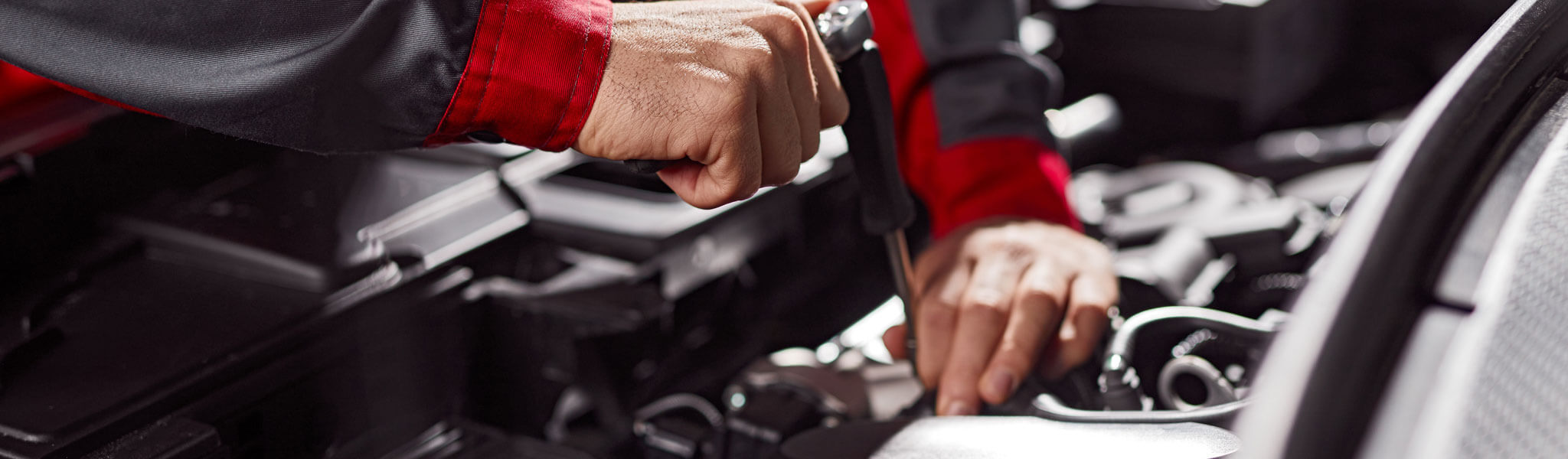 Mechanic Repairing Automobile Engine In Workshop